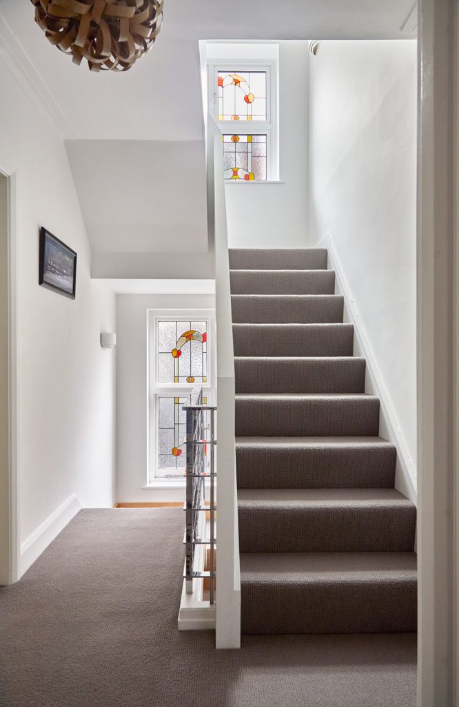 Original staircase with period stained-glass windows, retained during the East Finchley house refurbishment